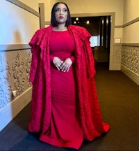 a woman in a red dress standing in a hallway