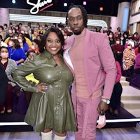 a man and woman posing for a picture in front of a crowd