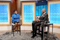 a man and woman sitting on chairs on a television set