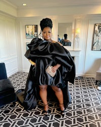 a woman in a black dress posing in a room